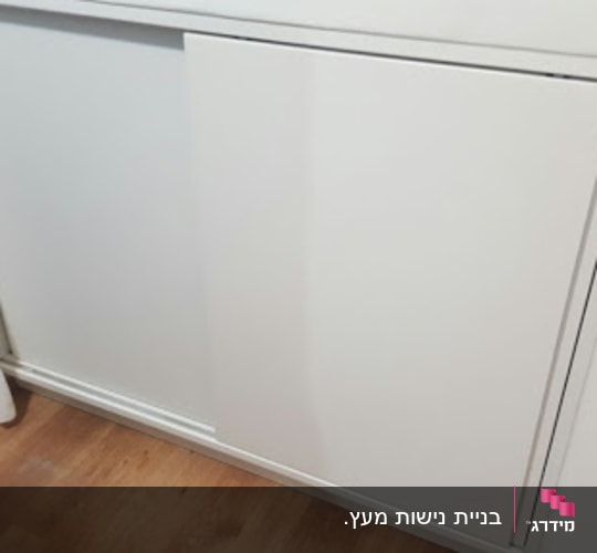 דלת הזזה לבנה על רקע קיר לבן